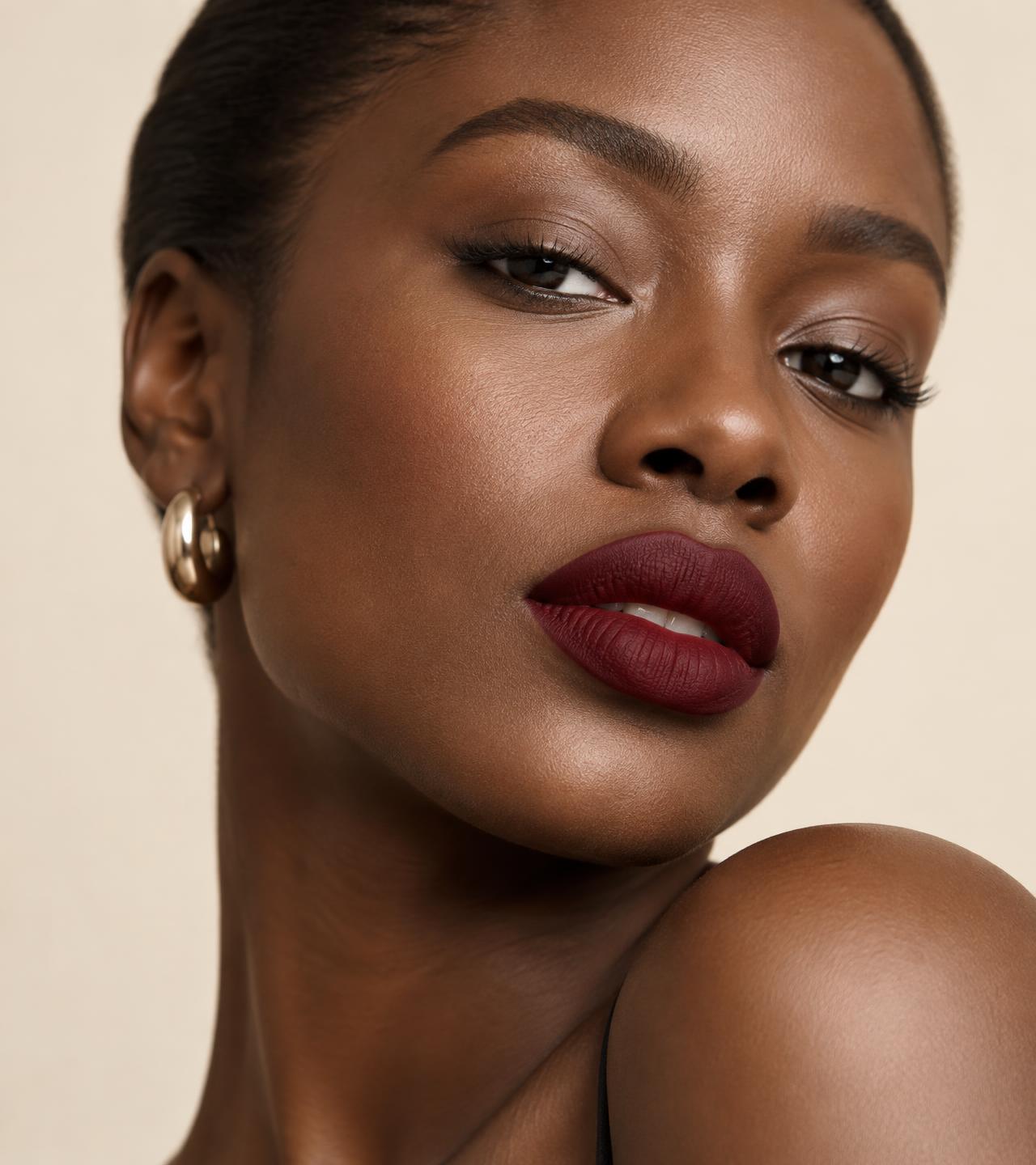 Model wearing a deep BRAM liquid matte lipstick